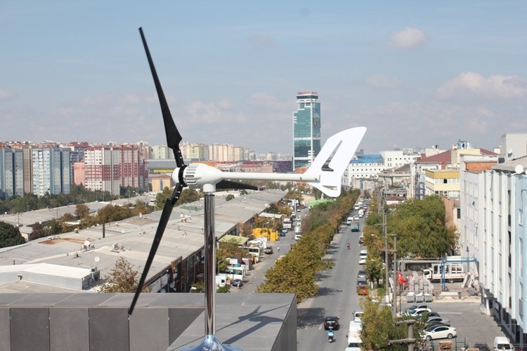 Şehir manzarasına kurulmuş rüzgar türbini direği